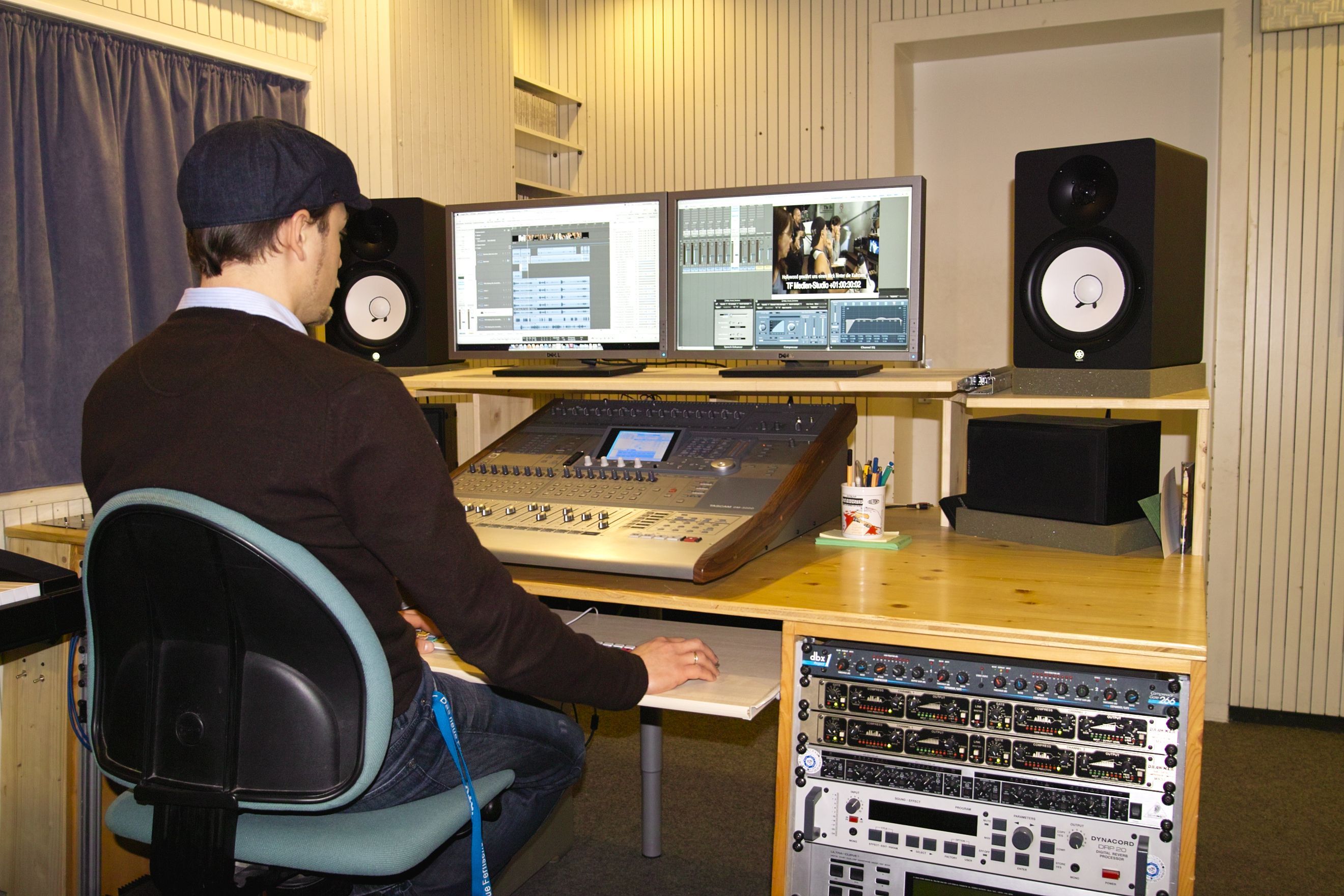 Ein Junge sitzt im Medienstudio am Computer. Auf dem Tisch sieht man außerdem ein ausgebautes Aufnahme-Equipment.